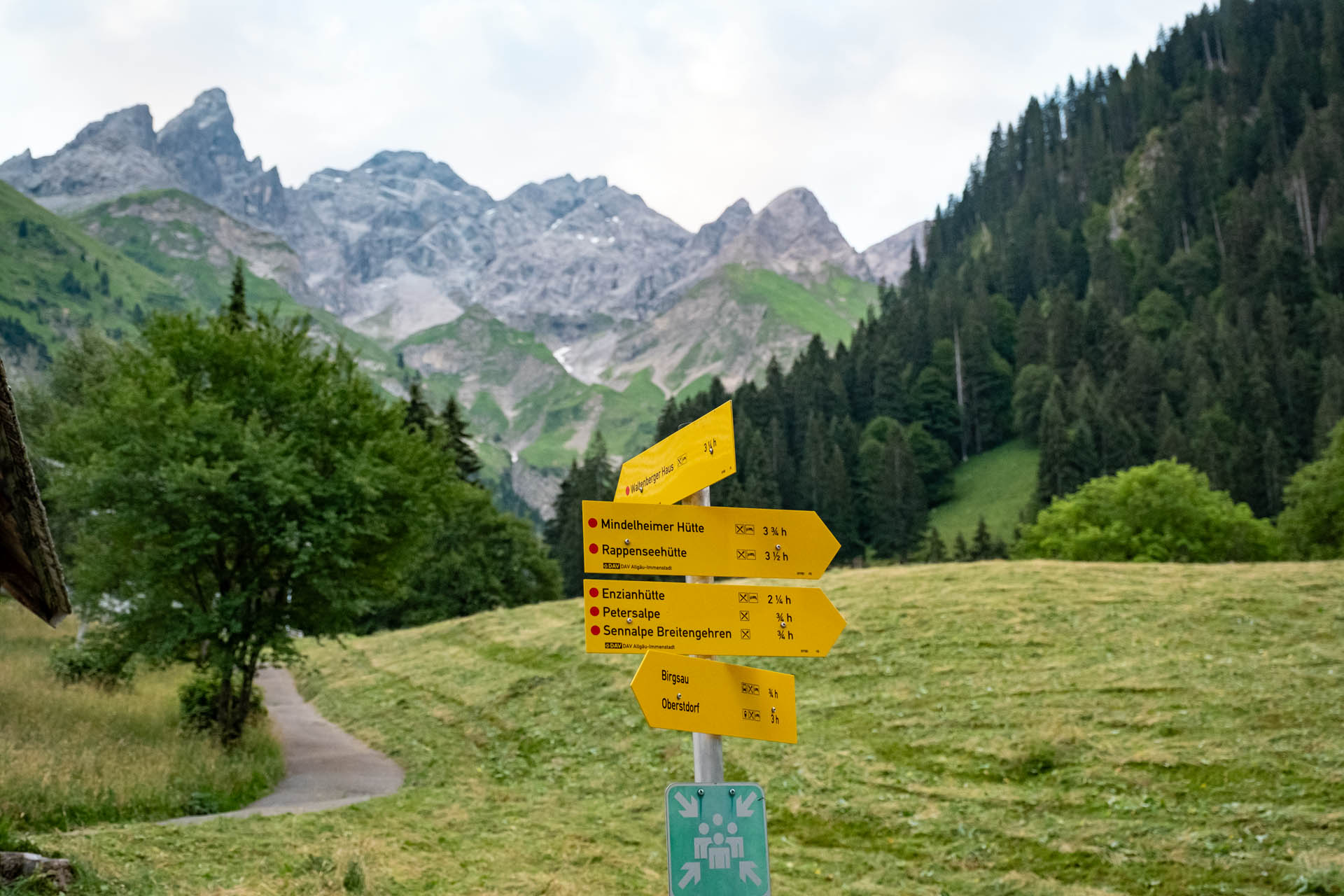 Wegweiser in Einödsbach Richtung Rappenseehütte und Hohes Licht mit Bergpanorama im Hintergrund