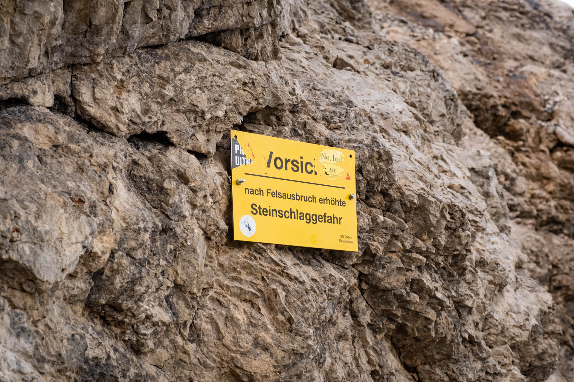 Warnschild auf Steinschlaggefahr nach Felssturz